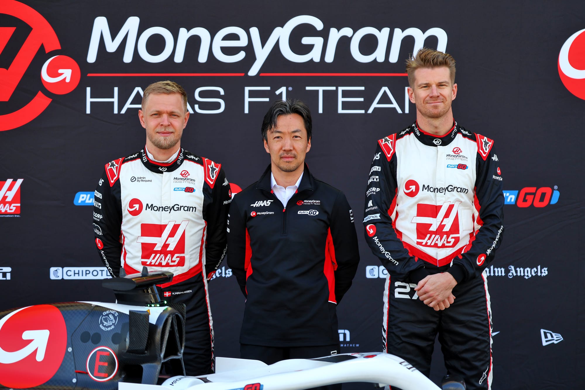 Kevin Magnussen, Ayao Komatsu and Nico Hulkenberg pose as the new Haas F1 car is revealed