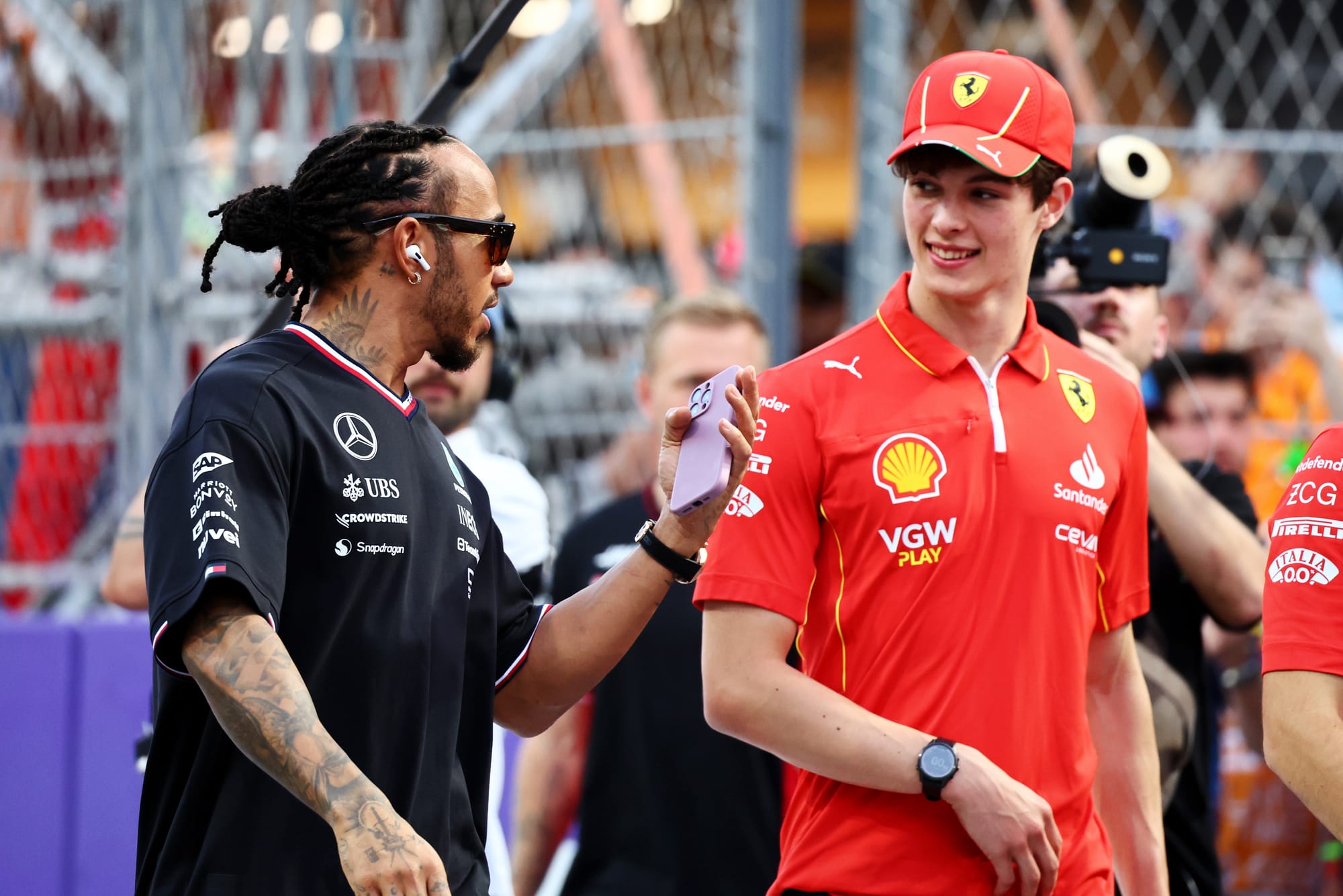 Mercedes' Lewis Hamilton (left) and Ferrari's Ollie Bearman (right) talking and walking at the Saudi Arabian Grand Prix 2024