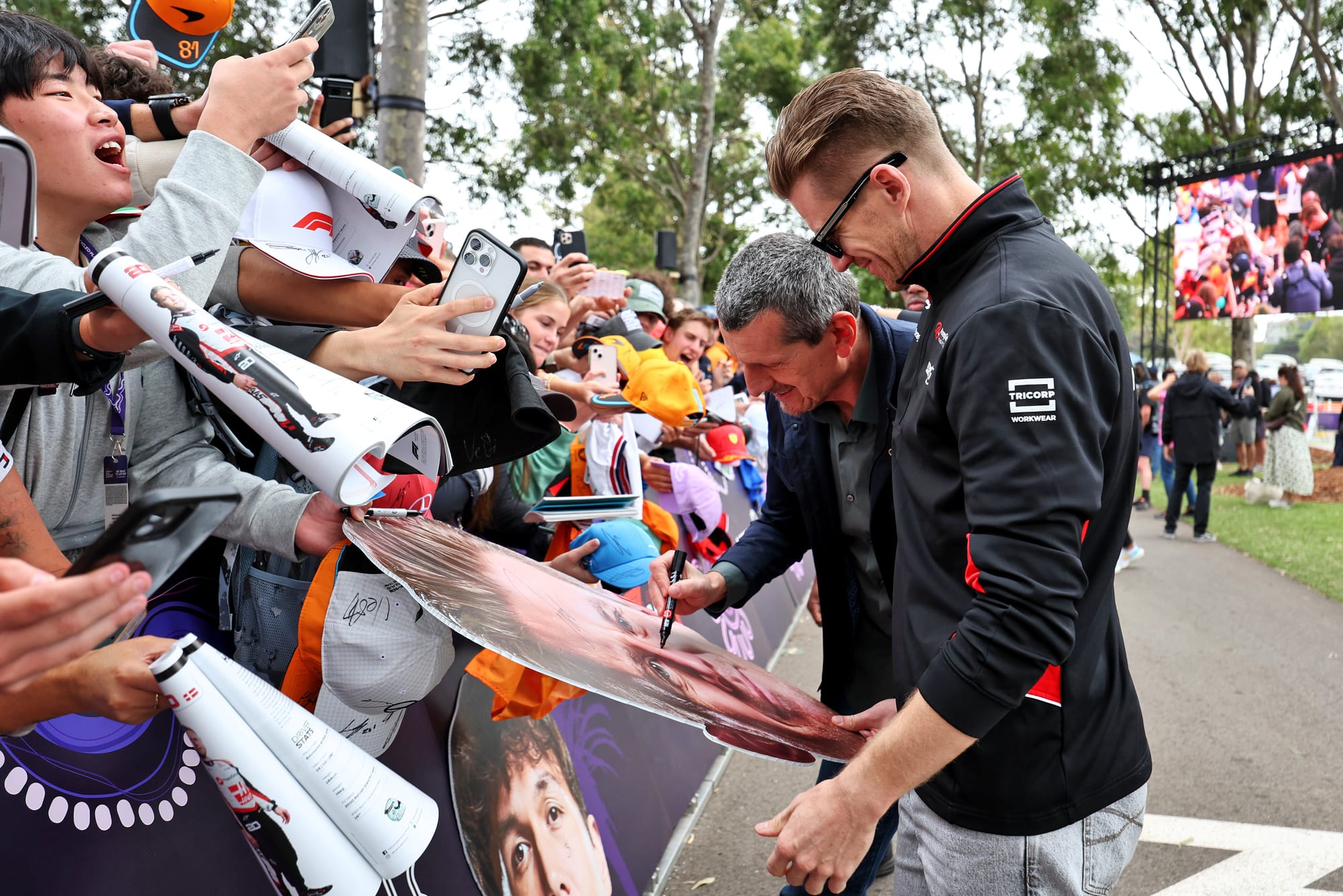 Guenther Steiner and Nico Hulkenberg sign autographs