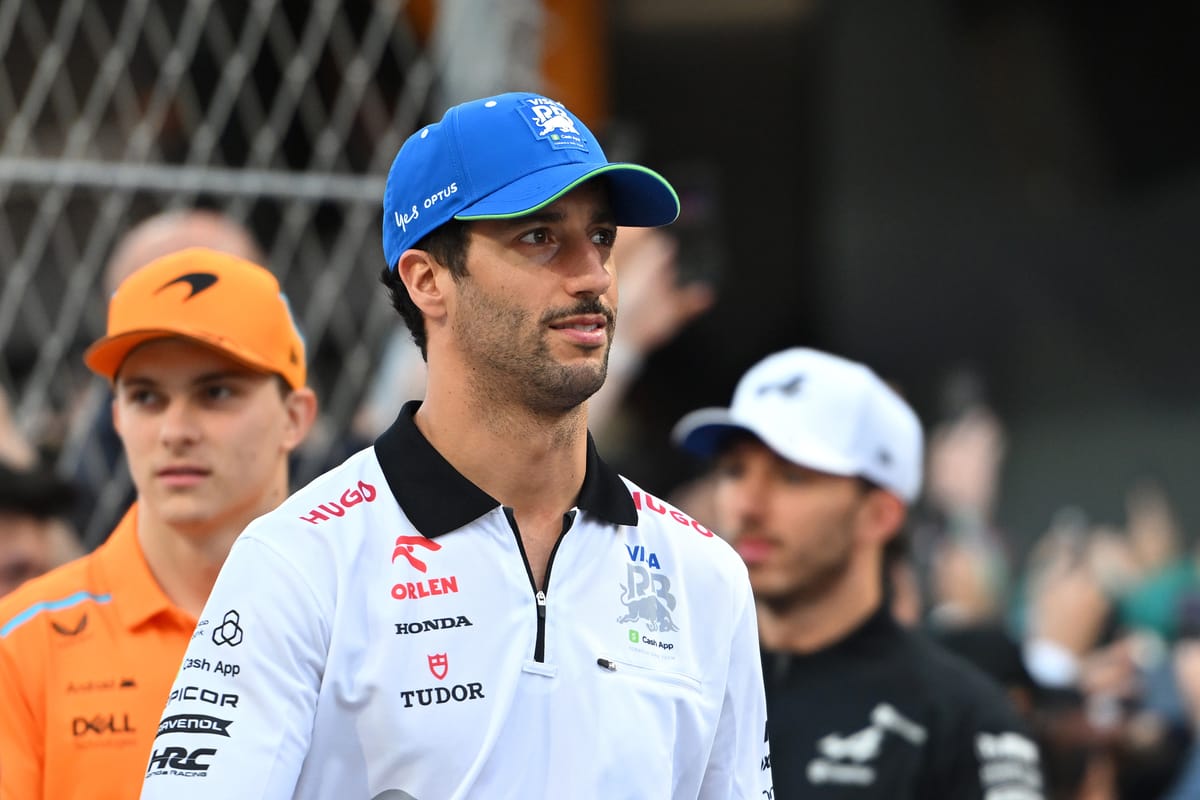 RB's Daniel Ricciardo looks to his left with Oscar Piastri of McLaren stood just behind, 2024